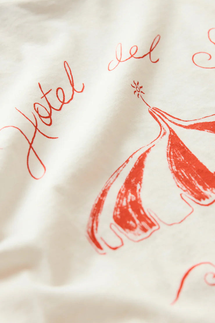 Woman wearing a white short-sleeve graphic T-shirt with red print, fabric/print detail