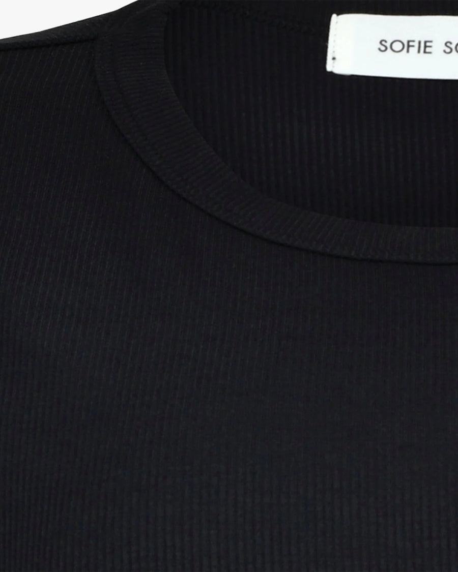 Woman wearing a black short-sleeve crewneck top with a relaxed fit, detail view