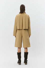 Woman wearing tan high-waisted wide-leg shorts , back
