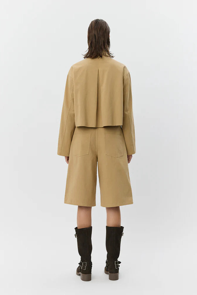 Woman wearing tan high-waisted wide-leg shorts , back