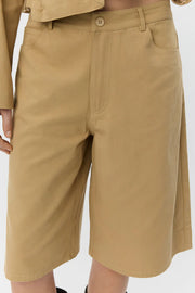 Woman wearing tan high-waisted wide-leg shorts, front detail