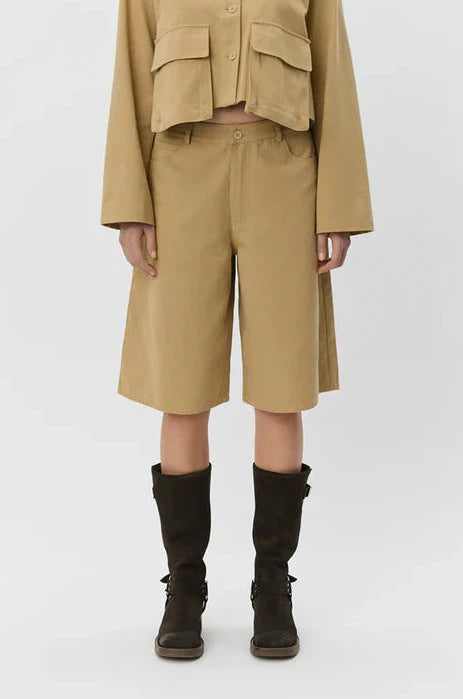 Woman wearing tan high-waisted wide-leg shorts, front