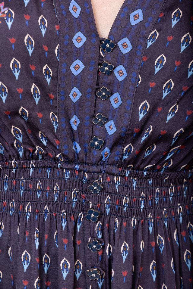 Close-up view of woman wearing a patterned navy blue long sleeve midi dress