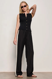 Woman wearing black lightweight  wide-leg pants with contrasting black side stripe detailing. Features a comfortable pull-on elastic waistband, relaxed fit through the leg, and a fluid full-length silhouette. Designed with side pockets and a soft drape for effortless everyday wear, front