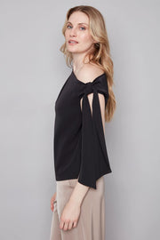 Side view of woman wearing a wide neckline off The shoulder top in black