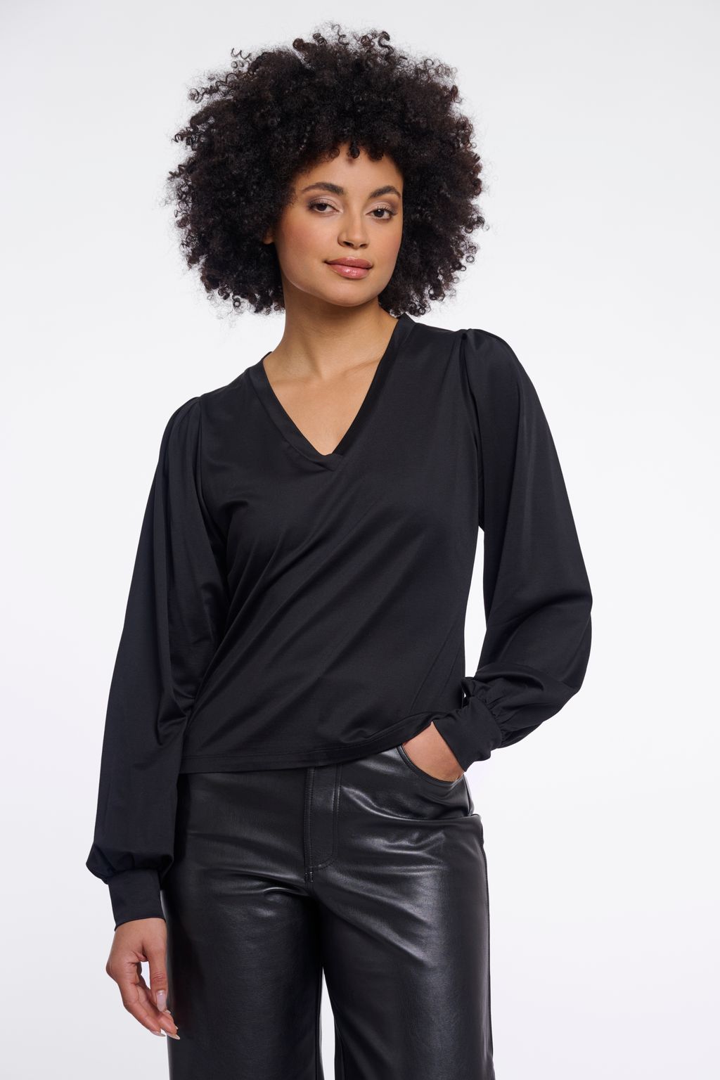Woman wearing a black v-neck blouse. 