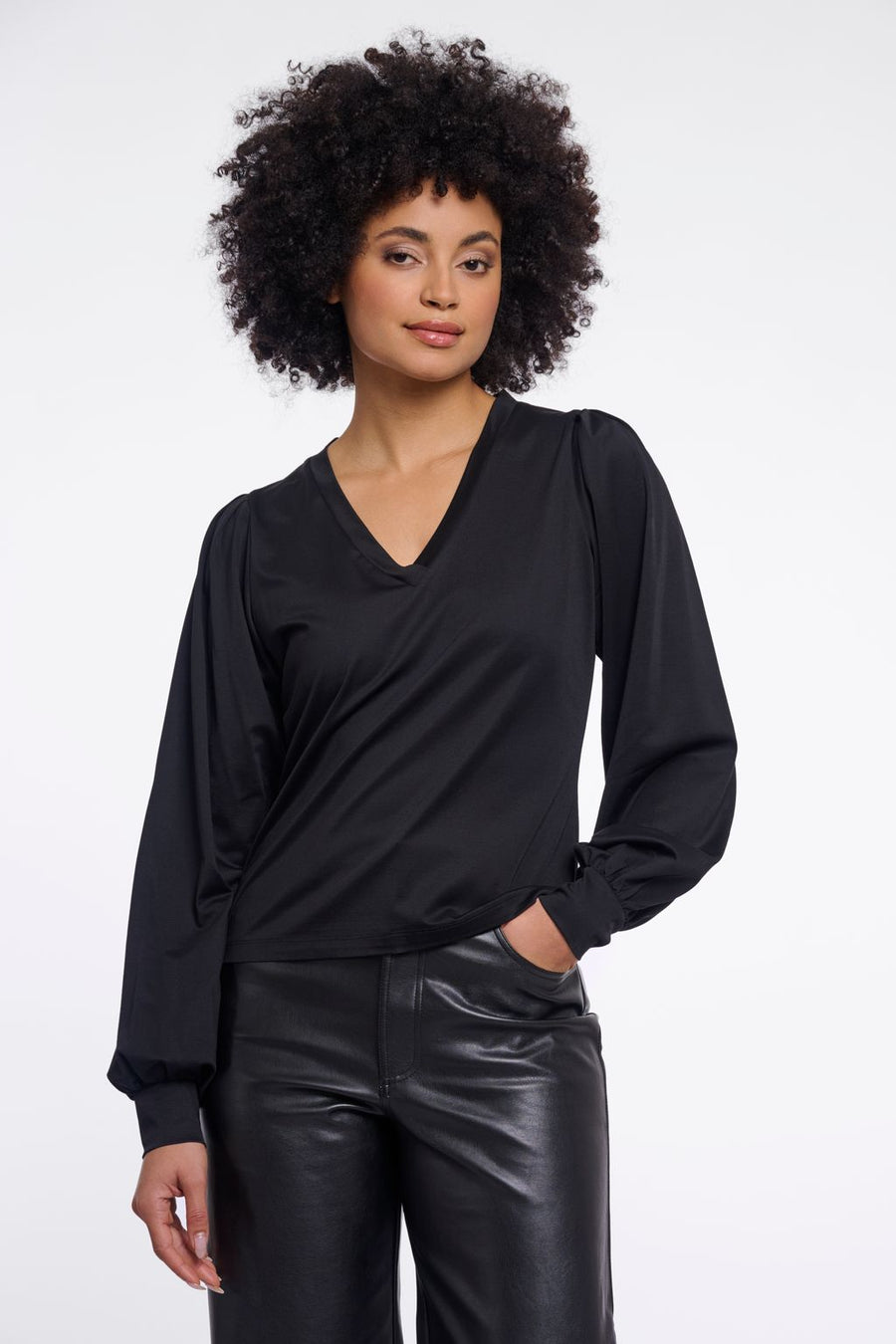 Woman wearing a black v-neck blouse. 