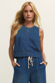 Woman wearing a denim tank top in a dark blue wash, front view