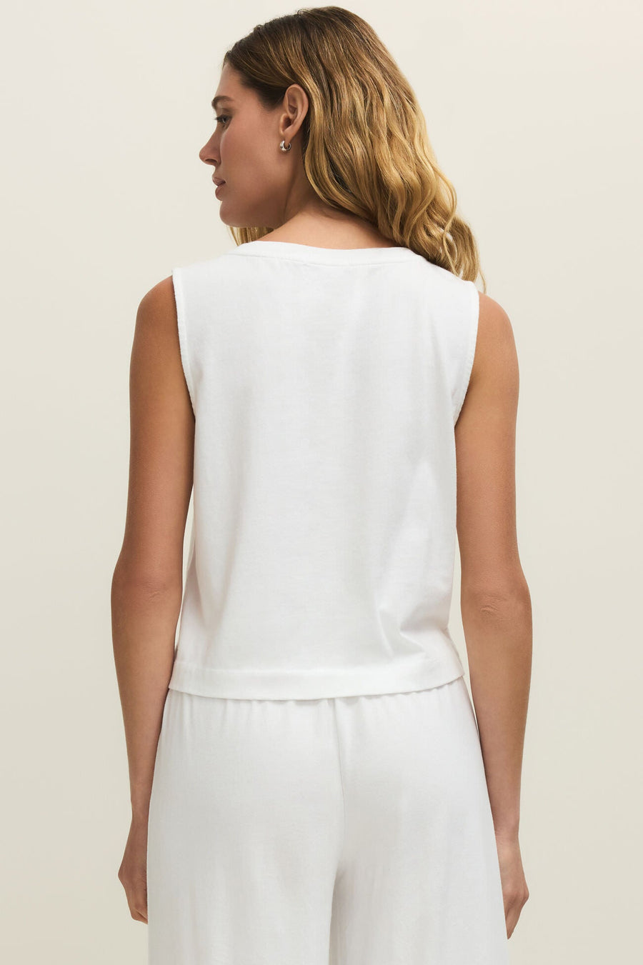 Woman wearing a plain white v-neck tank top, back view