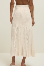 Woman wearing a cream knit midi skirt with elastic waistband, back view