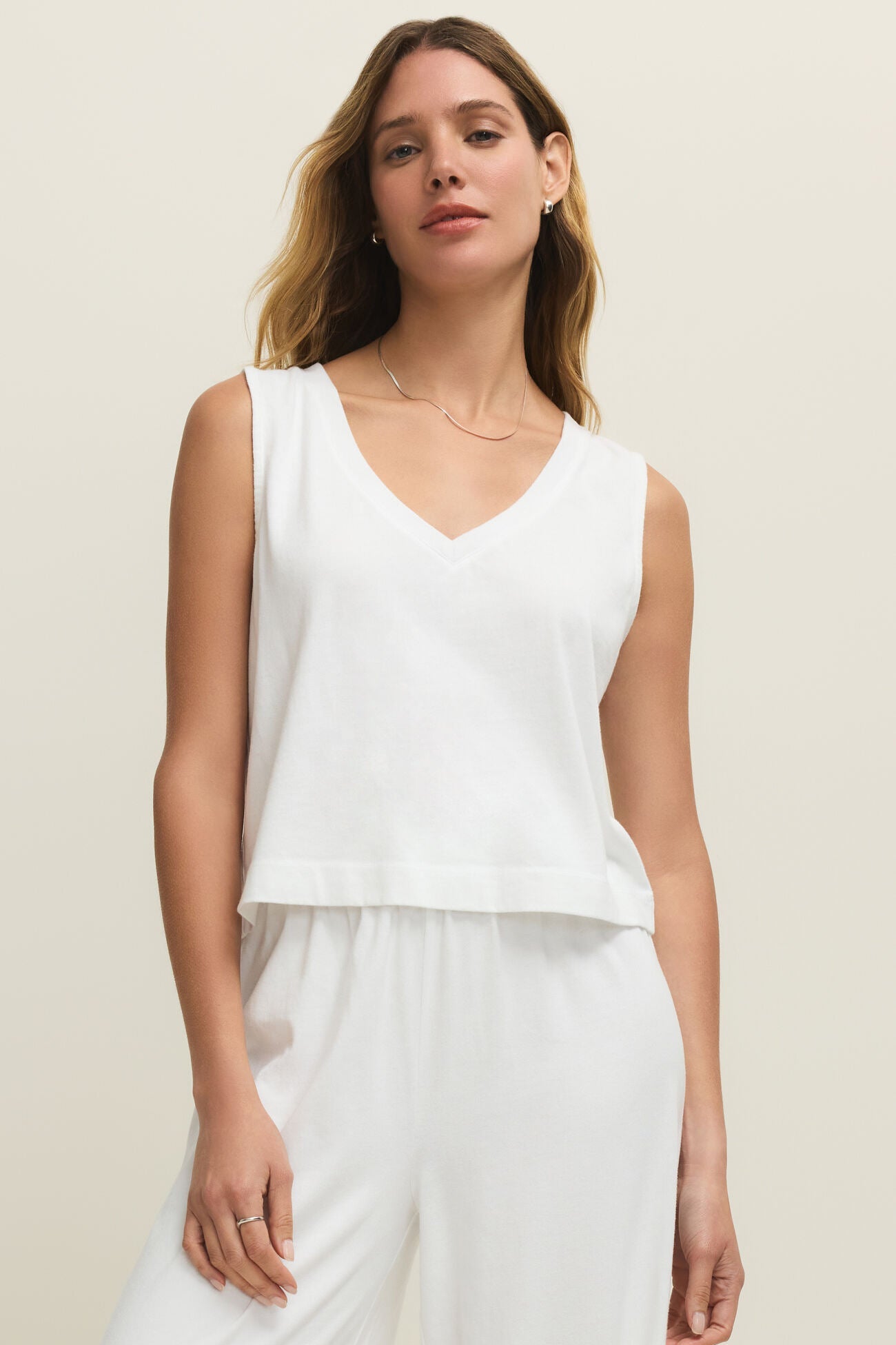 Woman wearing a plain white v-neck tank top, front view