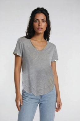 A woman modeling a light gray heathered short-sleeve V-neck top with a slightly asymmetrical hem,