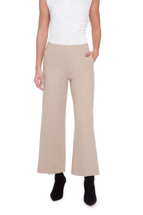 Person wearing beige flared pants and a white top on a white background