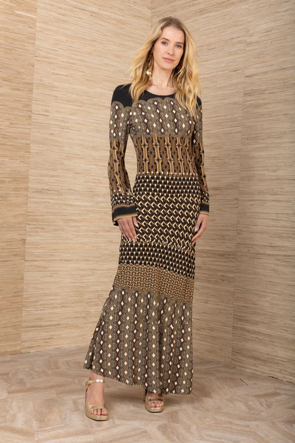 Front full-body view of woman wearing a black, brown and mustard yellow patterned maxi jersey long sleeve dress.