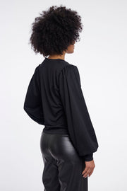Woman wearing a black v-neck blouse. 
